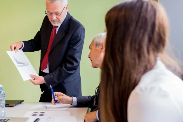 mature-businessman-showing-graph-his-business-partner-office mature-businessman-showing-graph-his-business-partner-office